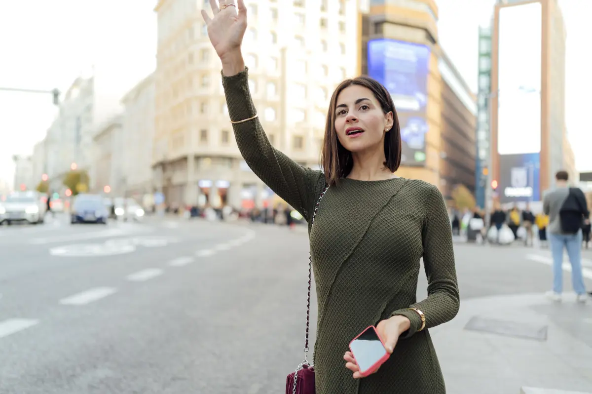 Mujer buscando taxi con el móvil